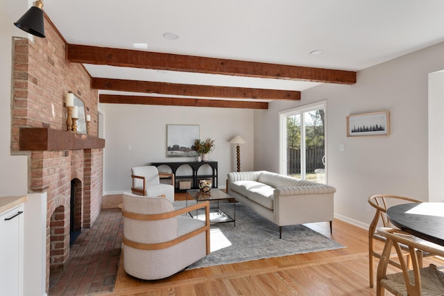 living area with beamed ceiling, light wood-style flooring, and baseboards