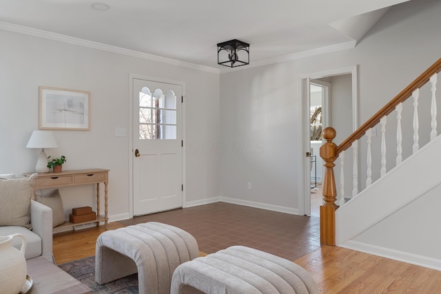 foyer entrance with baseboards, wood finished floors, and ornamental molding