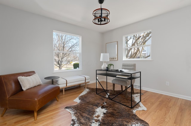 office featuring light wood-type flooring, baseboards, and an inviting chandelier