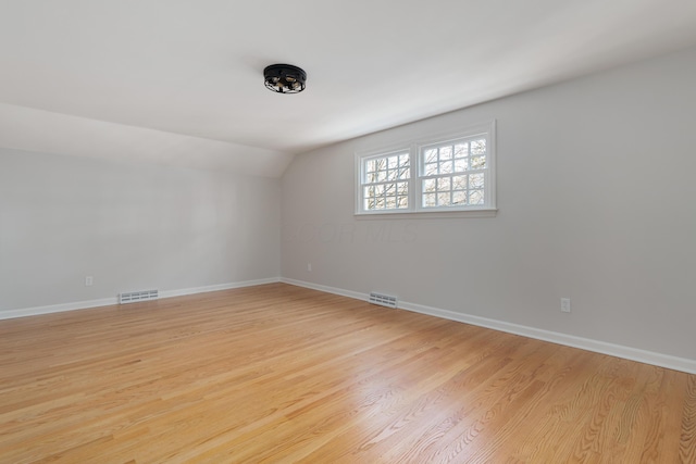 unfurnished room with vaulted ceiling, visible vents, and light wood finished floors