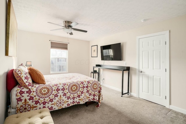 bedroom featuring baseboards, carpet floors, a textured ceiling, and ceiling fan