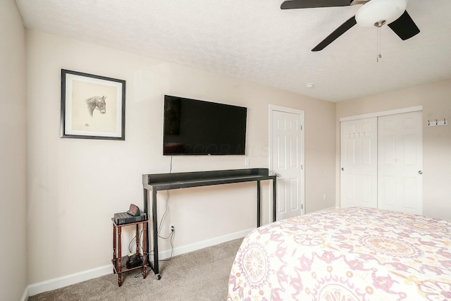 bedroom with a closet, a textured ceiling, baseboards, and carpet