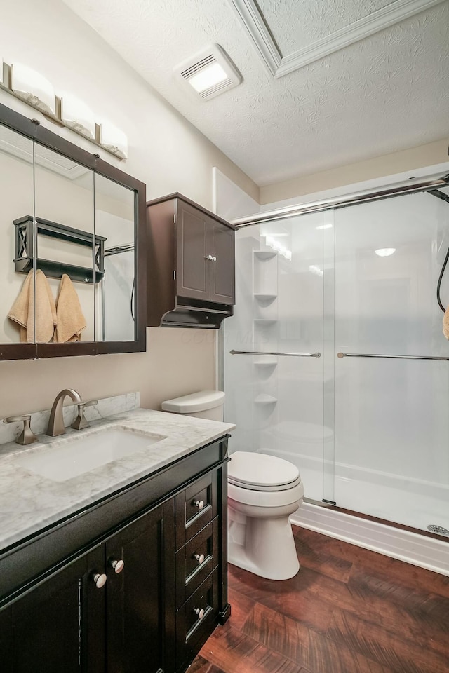 full bathroom with visible vents, toilet, a stall shower, a textured ceiling, and vanity