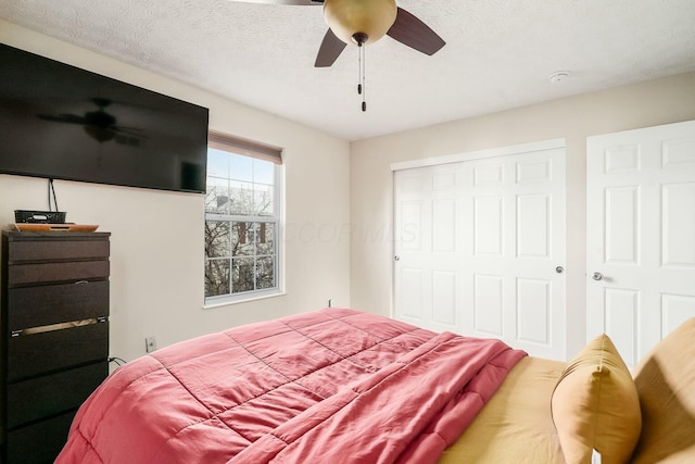 bedroom with ceiling fan, a closet, and a textured ceiling