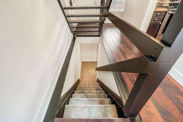 staircase with baseboards and wood finished floors