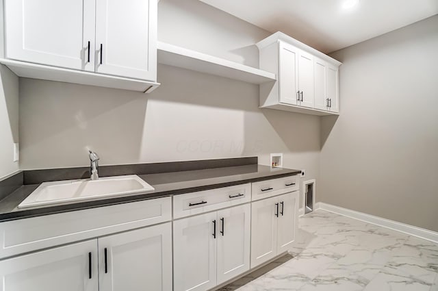 laundry area featuring hookup for a washing machine, baseboards, cabinet space, a sink, and marble finish floor