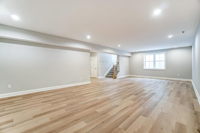 basement featuring recessed lighting, stairway, baseboards, and light wood finished floors