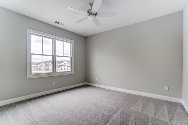 unfurnished room with carpet, a ceiling fan, and baseboards