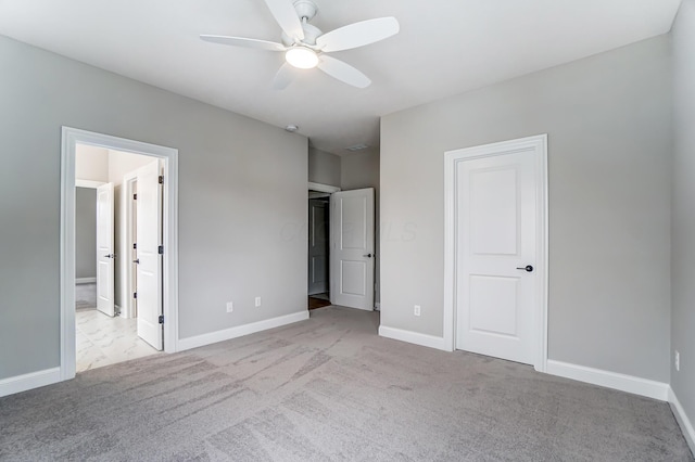 unfurnished bedroom with ensuite bath, a ceiling fan, baseboards, and carpet floors