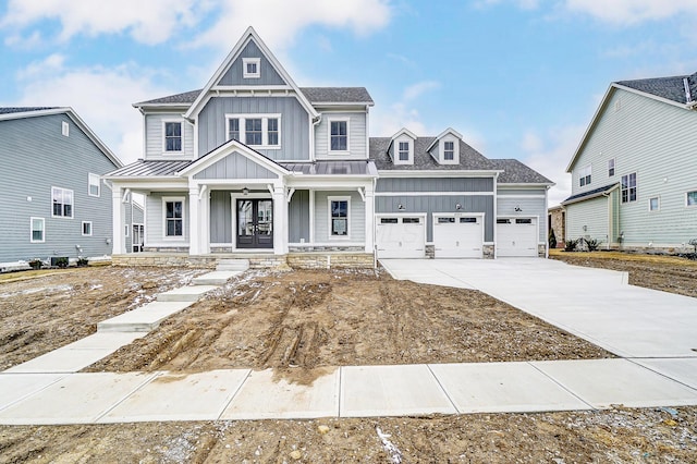 view of front facade featuring a porch, board and batten siding, an attached garage, and driveway