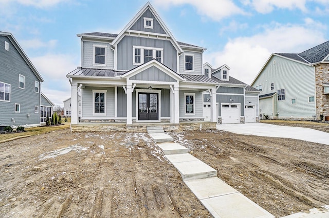 view of front of property with a standing seam roof, french doors, board and batten siding, concrete driveway, and metal roof