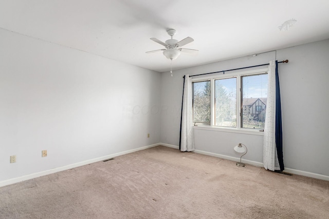 empty room featuring visible vents, carpet flooring, a ceiling fan, and baseboards