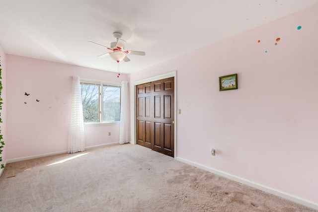 unfurnished bedroom featuring a closet, baseboards, a ceiling fan, and carpet flooring