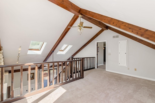 bonus room featuring a ceiling fan, baseboards, visible vents, lofted ceiling with skylight, and carpet flooring