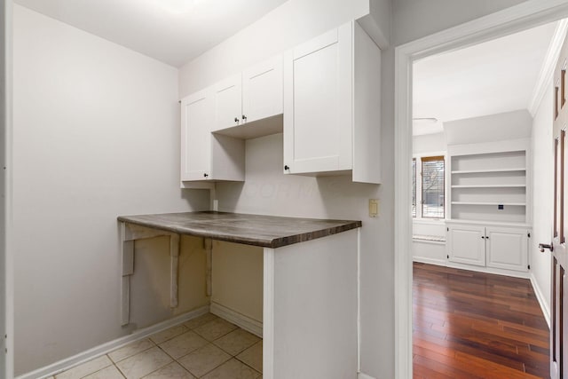 kitchen featuring dark countertops, white cabinetry, baseboards, and hardwood / wood-style floors