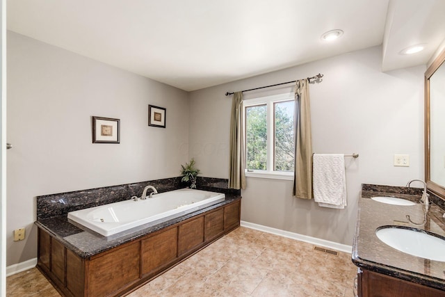 full bathroom with a sink, baseboards, a bath, and double vanity