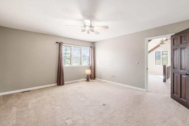 unfurnished room with visible vents, baseboards, and light colored carpet