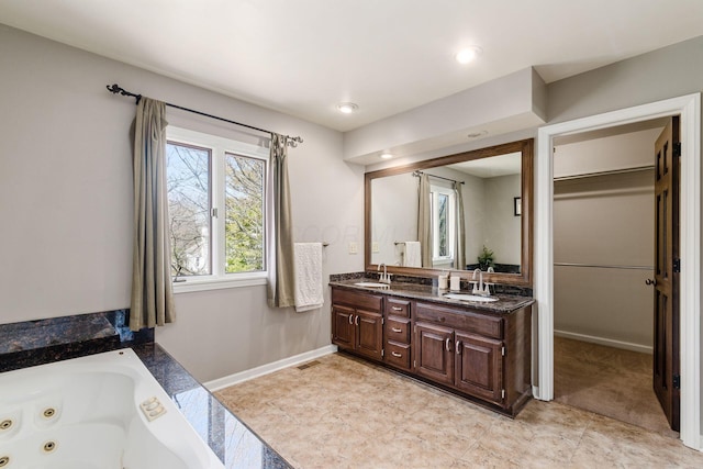 bathroom featuring a sink, visible vents, baseboards, and double vanity