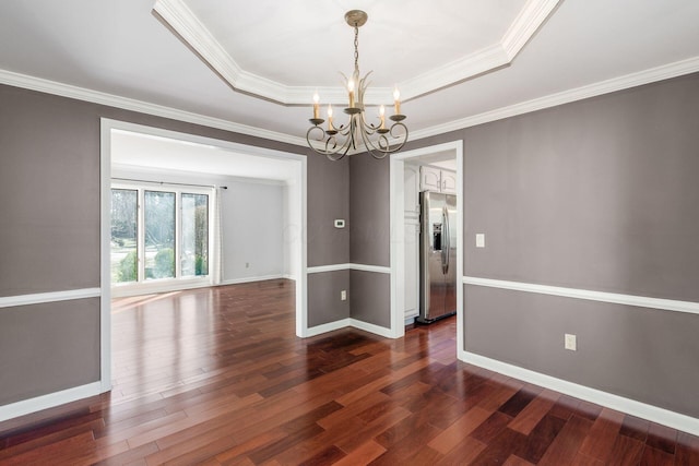 empty room featuring a chandelier, baseboards, dark wood-type flooring, and a tray ceiling