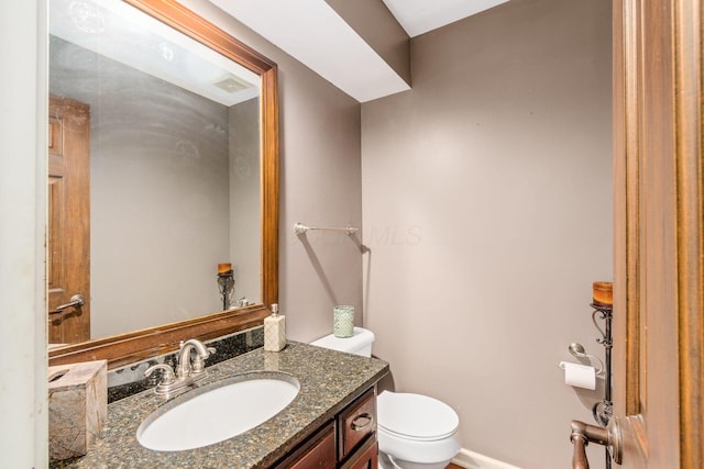 bathroom with visible vents, toilet, and vanity