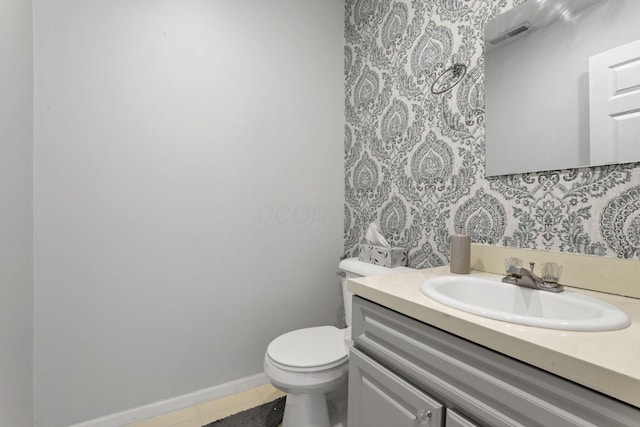 bathroom with vanity, visible vents, baseboards, tile patterned flooring, and toilet