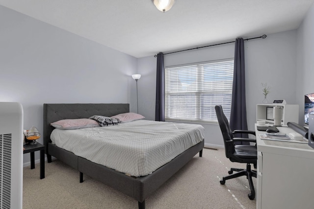 bedroom featuring light colored carpet and baseboards