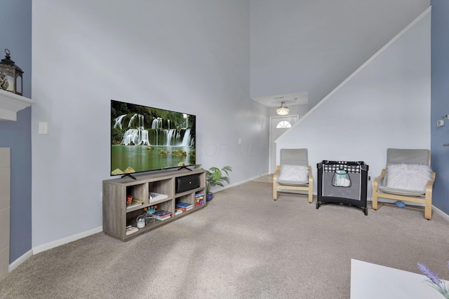 sitting room with a high ceiling, baseboards, and carpet floors