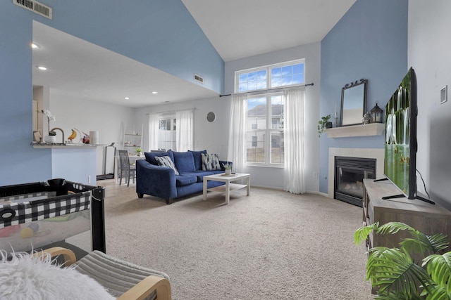 carpeted living area featuring recessed lighting, a fireplace, visible vents, and a towering ceiling