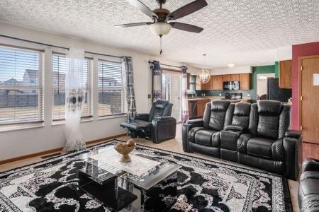 living room with baseboards, a textured ceiling, and a ceiling fan