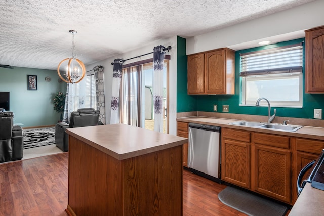 kitchen with a kitchen island, dark wood-style flooring, a sink, stainless steel dishwasher, and open floor plan