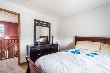 bedroom featuring carpet flooring, a textured ceiling, and baseboards