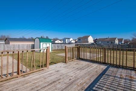 deck featuring fence, a residential view, a storage shed, a yard, and an outdoor structure