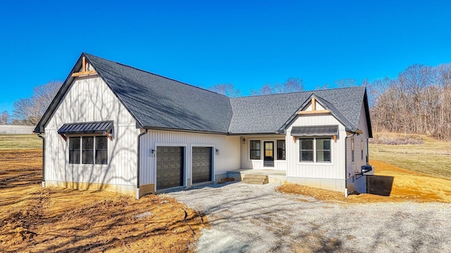 modern farmhouse style home featuring a garage, driveway, and a shingled roof