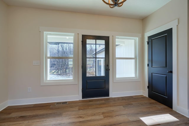 entrance foyer with visible vents, baseboards, and wood finished floors