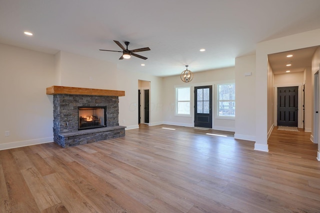 unfurnished living room featuring wood finished floors, recessed lighting, a fireplace, and baseboards