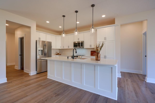 kitchen with light countertops, white cabinets, tasteful backsplash, and appliances with stainless steel finishes