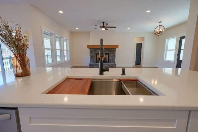 kitchen featuring recessed lighting, a stone fireplace, and a healthy amount of sunlight