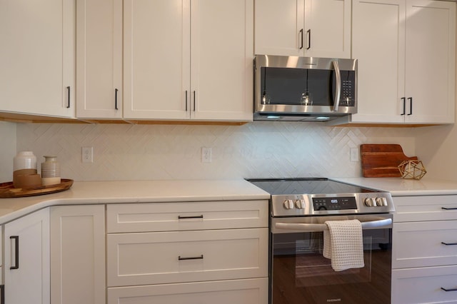 kitchen with decorative backsplash, appliances with stainless steel finishes, white cabinetry, and light countertops