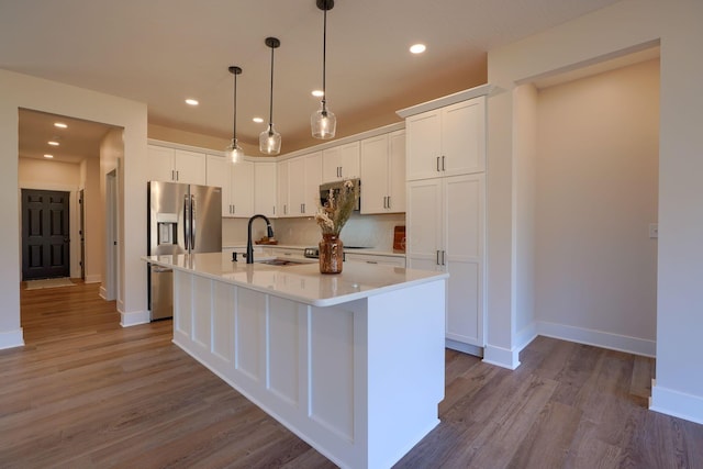 kitchen featuring a sink, appliances with stainless steel finishes, light countertops, and white cabinetry