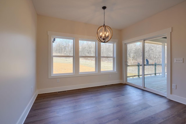 unfurnished dining area with a chandelier, baseboards, visible vents, and dark wood finished floors