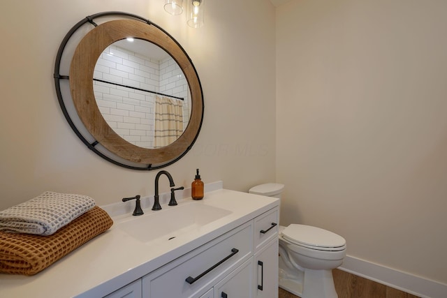 bathroom with vanity, a shower with curtain, wood finished floors, baseboards, and toilet