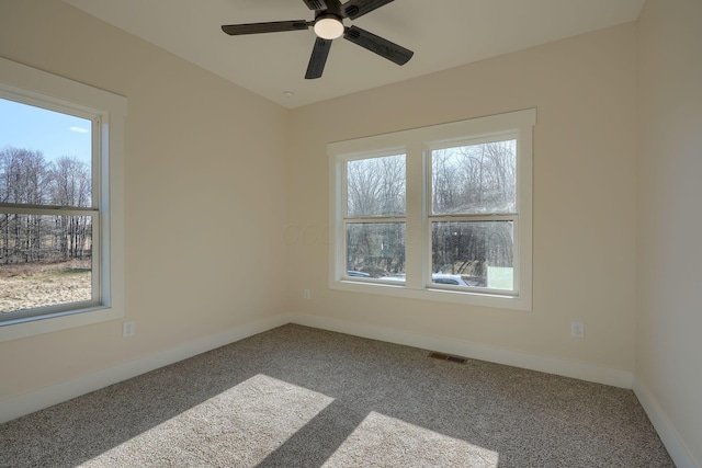 unfurnished room featuring a ceiling fan, carpet flooring, visible vents, and baseboards