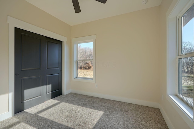 unfurnished bedroom with baseboards, carpet, and a ceiling fan