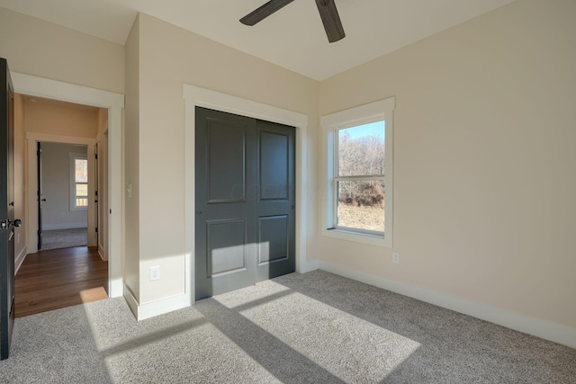 bedroom with a closet, baseboards, carpet, and ceiling fan