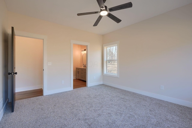 unfurnished bedroom with ceiling fan, ensuite bathroom, baseboards, and carpet floors