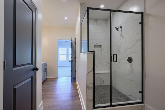 bathroom with baseboards, recessed lighting, a stall shower, wood finished floors, and vanity