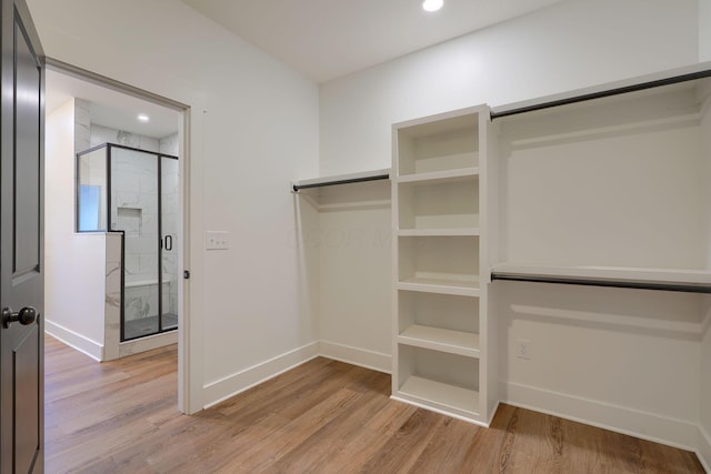 walk in closet with light wood-style flooring