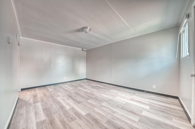 spare room with light wood finished floors and baseboards