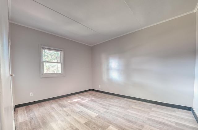 unfurnished room with baseboards, ornamental molding, and light wood finished floors