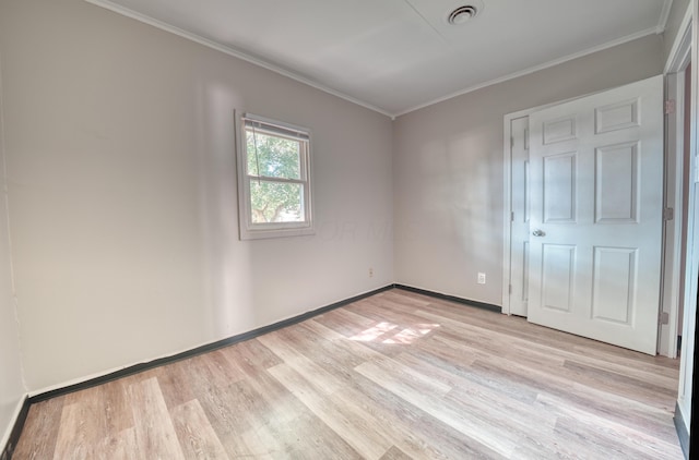 unfurnished bedroom featuring light wood finished floors, visible vents, baseboards, and ornamental molding